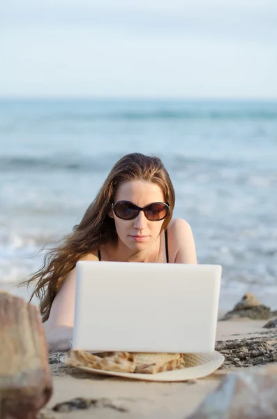 Vrouw met laptop werken op het strand. plaats voor tekst. — Stockfoto