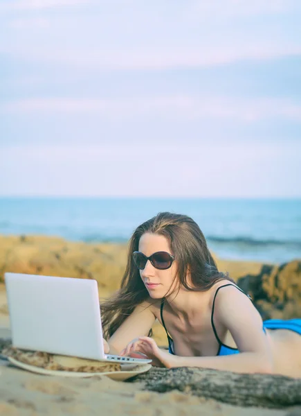 Donna con un portatile che lavora sulla spiaggia. Posto per testo . — Foto Stock