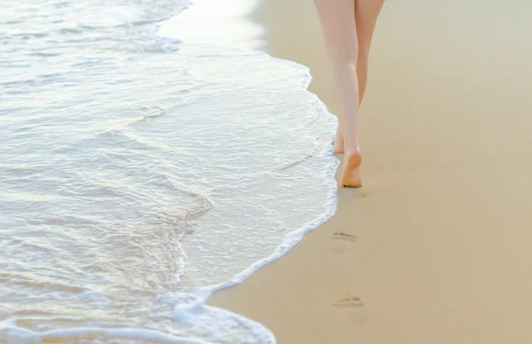 Pair of female legs on a seashore. — Stock Photo, Image