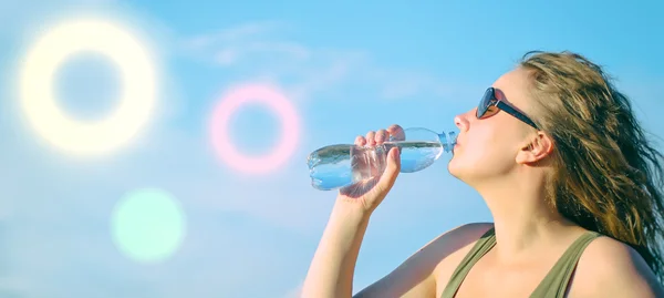 Приваблива жінка п'є воду . — стокове фото