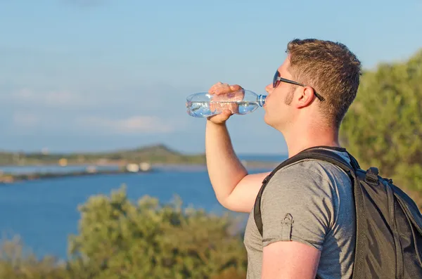 Male tourist tired. Drinking water. — Stock Photo, Image