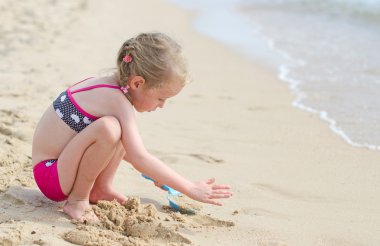 Kumsalda oynayan küçük kız..