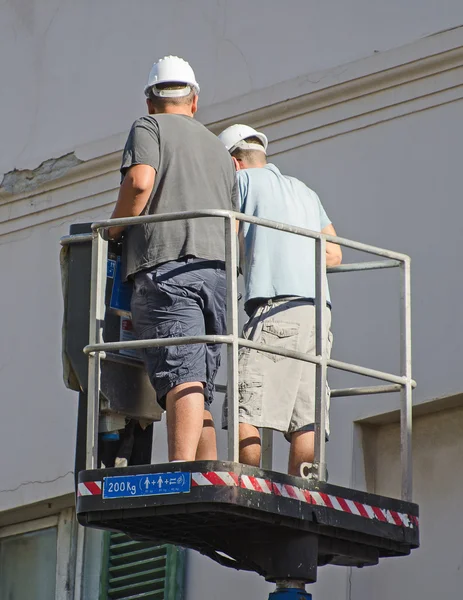 Hydraulic lift with two workers. — Stock Photo, Image