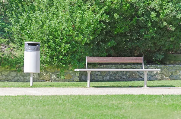 Скамейка и мусорное ведро в парке . — стоковое фото