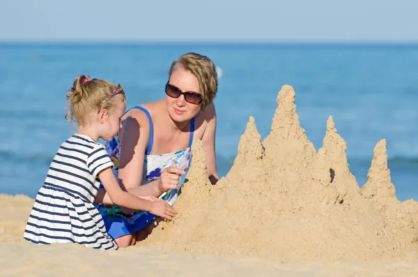 Rodziny z zamku z piasku na plaży. — Zdjęcie stockowe