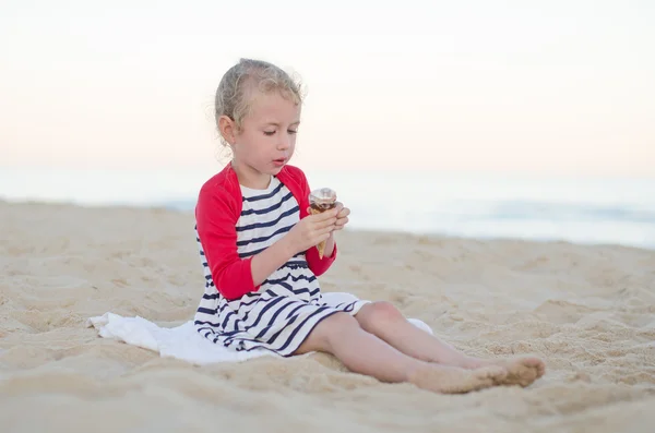 Ragazzina che mangia gelato sulla spiaggia . — Foto Stock