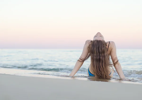 Kobieta na plaży o zachodzie słońca. — Zdjęcie stockowe