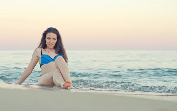 Donna seduta sulla sabbia della spiaggia . — Foto Stock