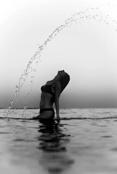 Woman in water waving hair. Black and white effect. — Stock Photo, Image