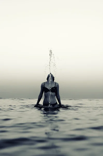 Woman in water waving hair. Black and white effect. — Stock Photo, Image