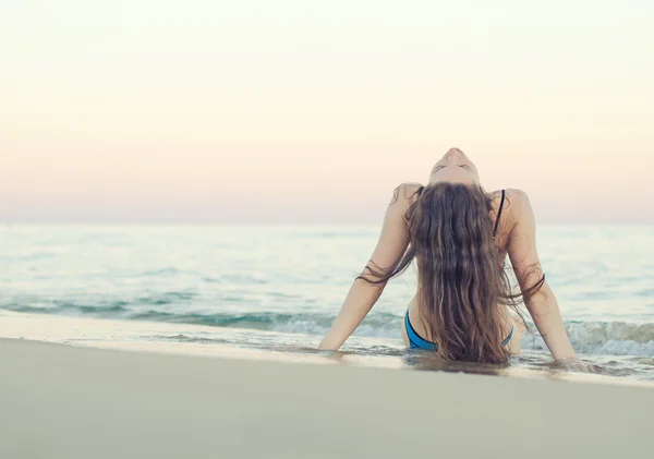 Mujer en la playa al atardecer. Efecto vintage . — Foto de Stock