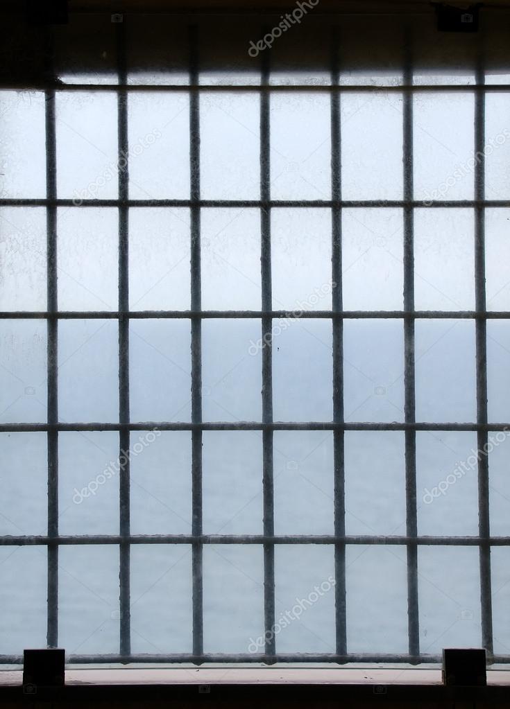 Barred prison window with ocean view.