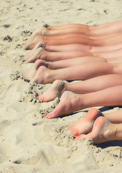 人々 は、ビーチでの日光浴します。人間の足άνθρωποι ηλιοθεραπεία στην παραλία. ανθρώπινα πόδια. — Φωτογραφία Αρχείου