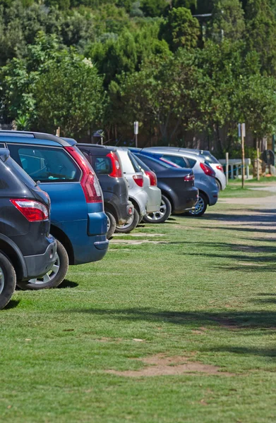 Cars parked in a parking lot on the grass. — Stock Photo, Image