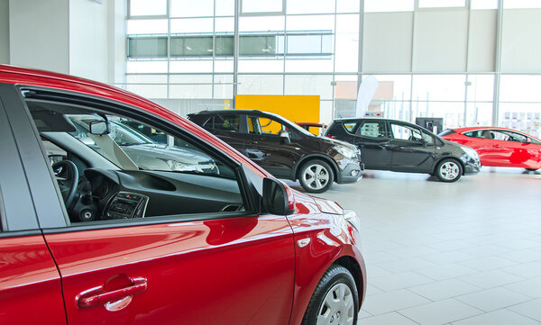 Several new cars at dealership salon.
