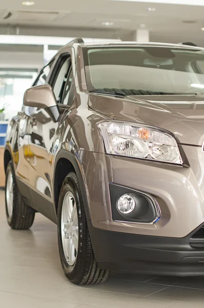 Grijze nieuwe auto op dealer salon. — Stockfoto