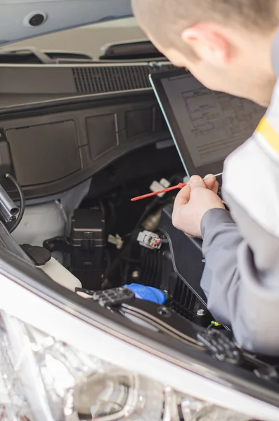 Mechanic meten het oliepeil in werkplaats. — Stockfoto