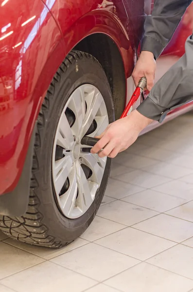 Mechanic fixing car wheel at service. — Stock Photo, Image