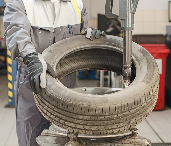 Mechaniker wechselt Autoreifen mit Perlenbrecherwerkzeug. — Stockfoto