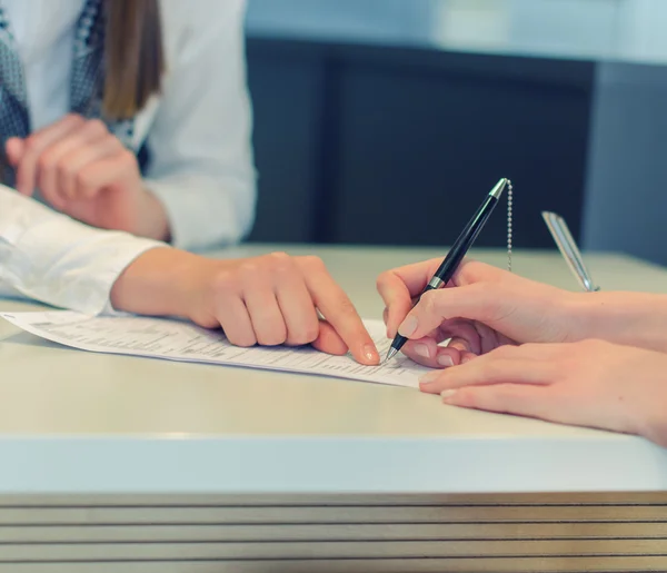 Vrouwelijke handen handtekening om overeenkomst document in office — Stockfoto