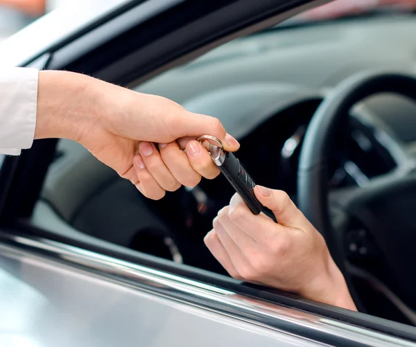 Vista de perto da mão feminina dentro do carro recebendo chaves — Fotografia de Stock