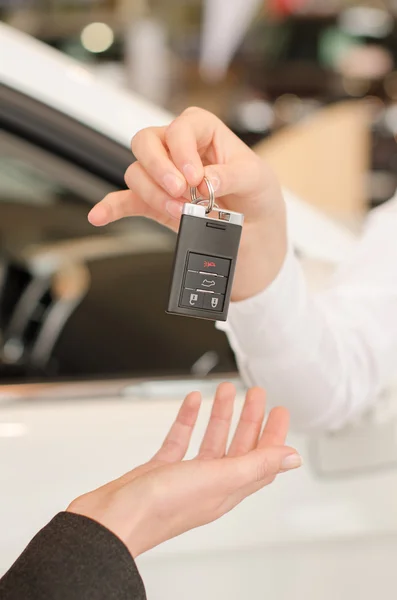 Mano femenina consiguiendo llave moderna del coche en un fondo del coche — Foto de Stock