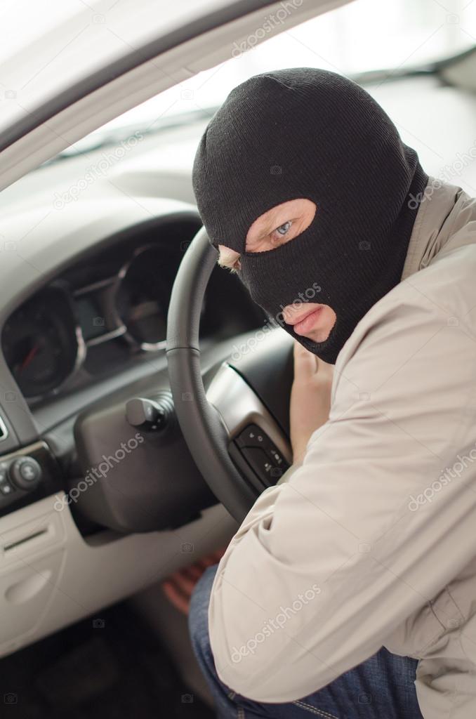 Thief in mask steals expensive new car.