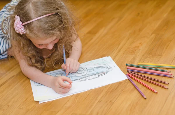 Маленькая девочка рисует машину с цветными карандашами . — стоковое фото