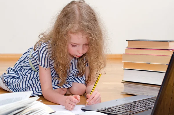 Petite fille intelligente écrit diplôme à la maison . — Photo