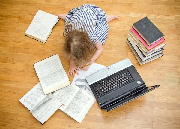 Una niña inteligente escribe un diploma en casa. Vista superior . —  Fotos de Stock