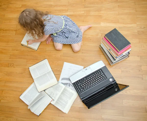 Petite fille intelligente écrit diplôme à la maison. Vue du dessus . — Photo