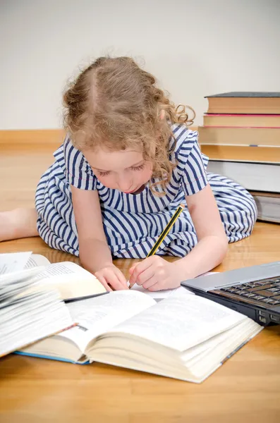 Petite fille intelligente écrit diplôme à la maison . — Photo