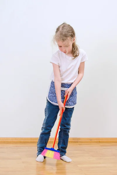 Pouco bonito menina brooming chão em casa . — Fotografia de Stock