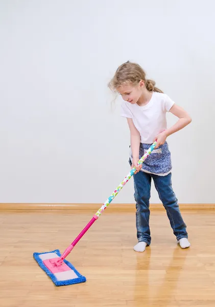 Pouco bonito menina esfregando chão em casa . — Fotografia de Stock