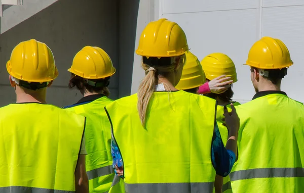Group of workers in hardhats. View from the back. — Stock Photo, Image