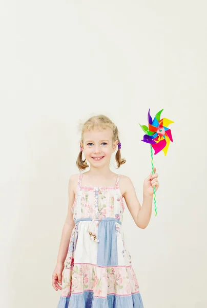 Niña con pinwheel colorido. Efecto vintage . — Foto de Stock