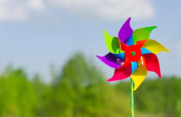 Childish pinwheel against blue sky background. — Stock Photo, Image