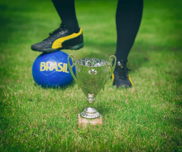 Zilveren voetbal trofee tegen voetballer. — Stockfoto