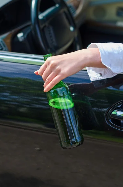Fahren unter Alkoholeinfluss. weibliche Hand mit Flasche Bier. — Stockfoto