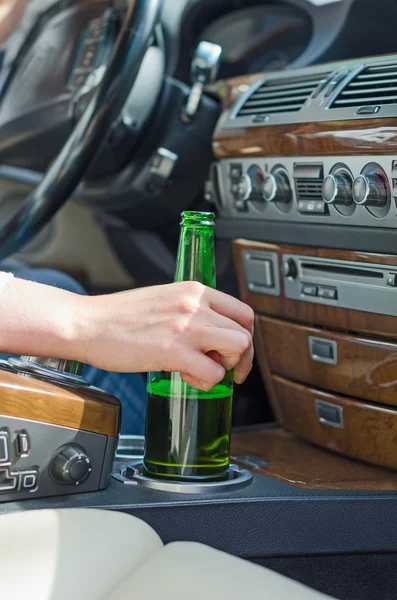 Conducir bajo la influencia. Mano femenina con botella de cerveza . — Foto de Stock