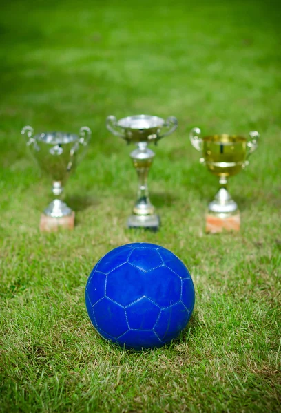 Celebración de la victoria. Trofeos de fútbol cerca de la pelota . — Foto de Stock