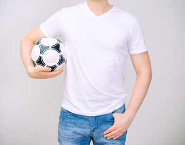 man in wit t-shirt met bal. grijze achtergrond.