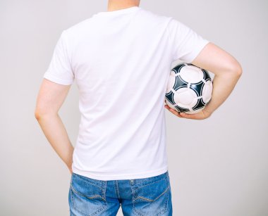 man in wit t-shirt met bal. grijze achtergrond.