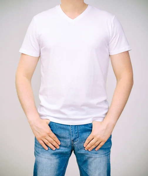 Muž v bílém tričku. šedé pozadí. — Stock fotografie