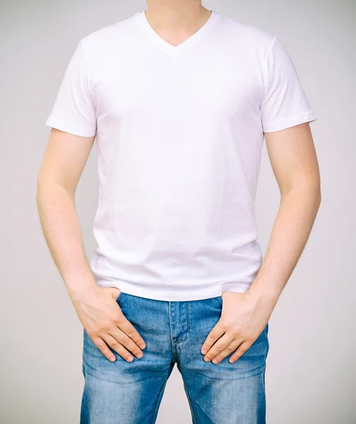 Man in wit t-shirt. grijze achtergrond. — Stockfoto