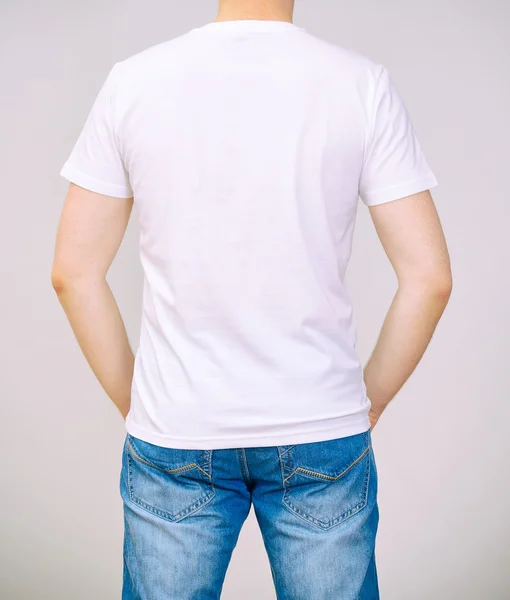 Man in wit t-shirt. grijze achtergrond. — Stockfoto