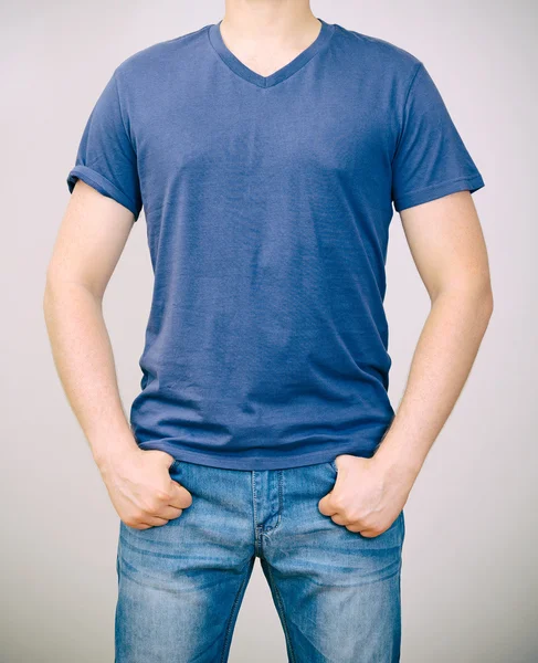 Mann im blauen T-Shirt. grauer Hintergrund. — Stockfoto