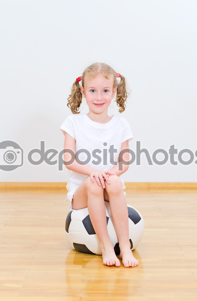 Little cute girl sitting on the soft ball.