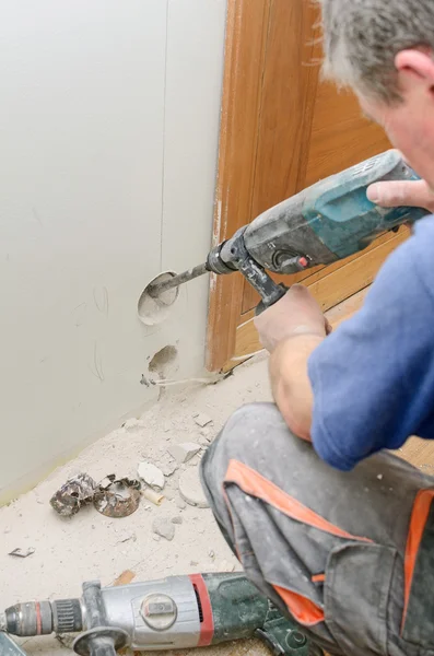 Man with Hammer drill doing hole for socket. — Stock Photo, Image