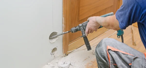 Homem com martelo furar fazendo buraco para soquete. Lugar para texto . — Fotografia de Stock